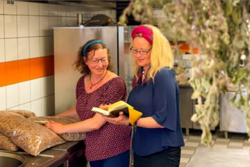 Frauen stehen in der Küche mit regionalen Lebensmitteln